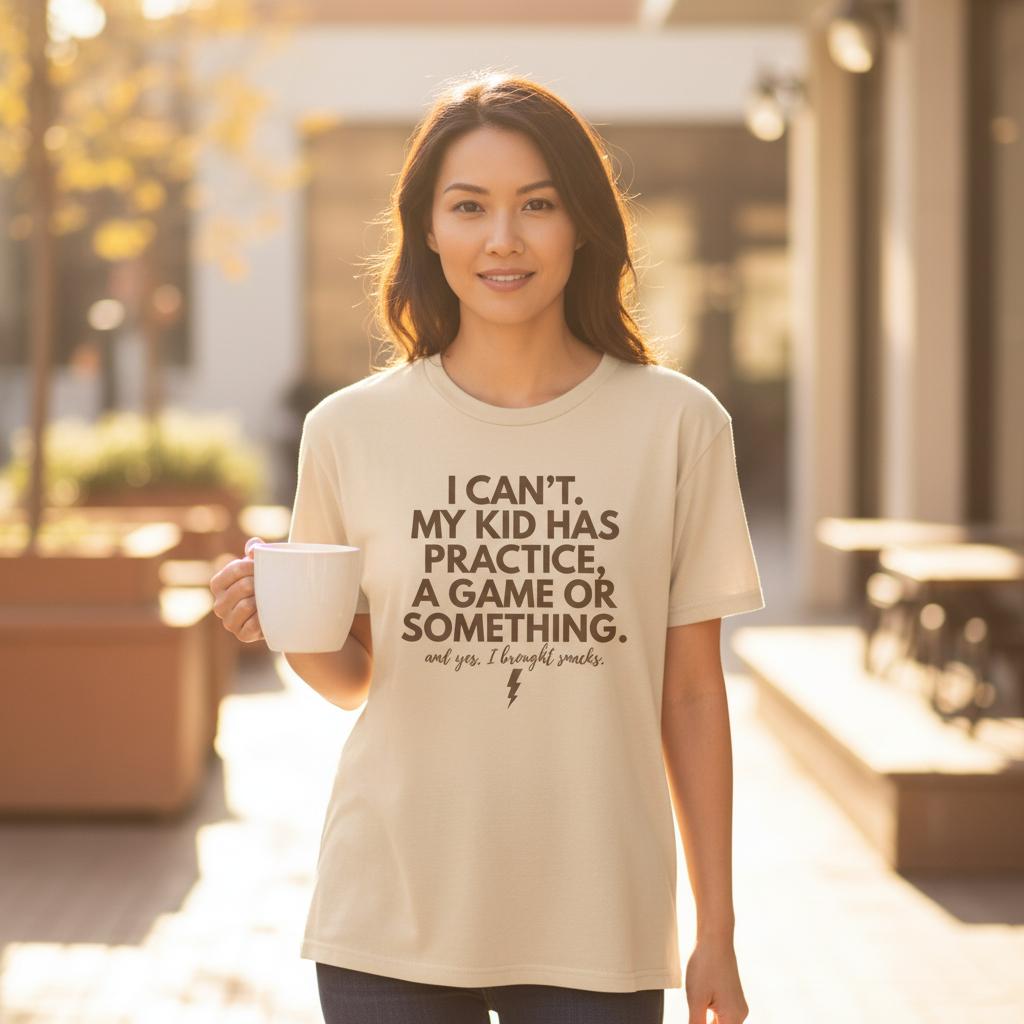 Close-up lifestyle photo of mom wearing funny mom shirt about kids’ schedules, holding coffee.