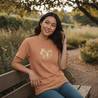 Load image into Gallery viewer, Woman wearing sandstone Aries Mama zodiac t-shirt outdoors in warm natural light