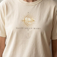 Close-up of Sagittarius Mama ivory t-shirt with gold zodiac graphic on chest
