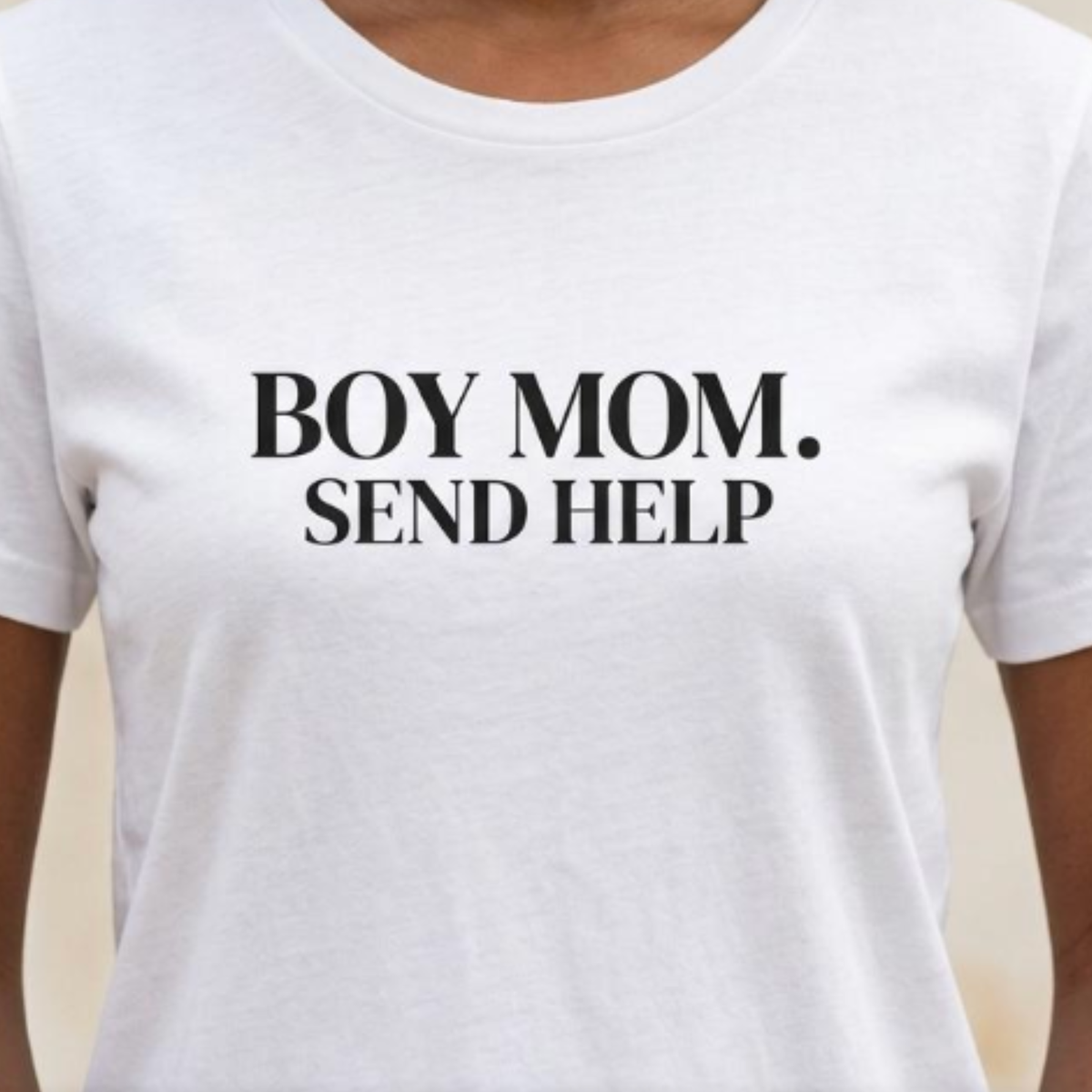 Close-up of white “Boy Mom. Send Help” graphic t-shirt showing bold black typography and print detail