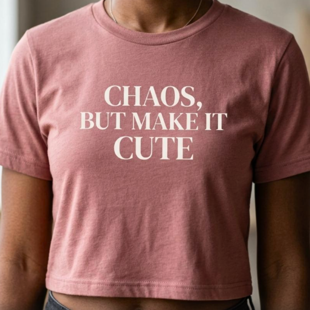 Close-up of mauve “Chaos, But Make It Cute” graphic t-shirt with soft white typography