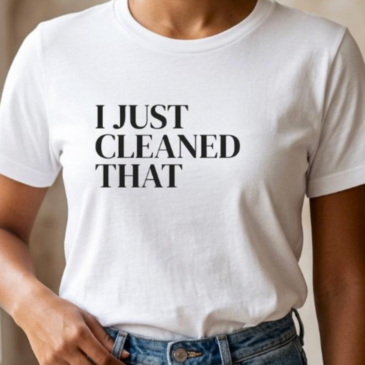 Close-up of white “I Just Cleaned That” graphic t-shirt showing bold black typography and print detail
