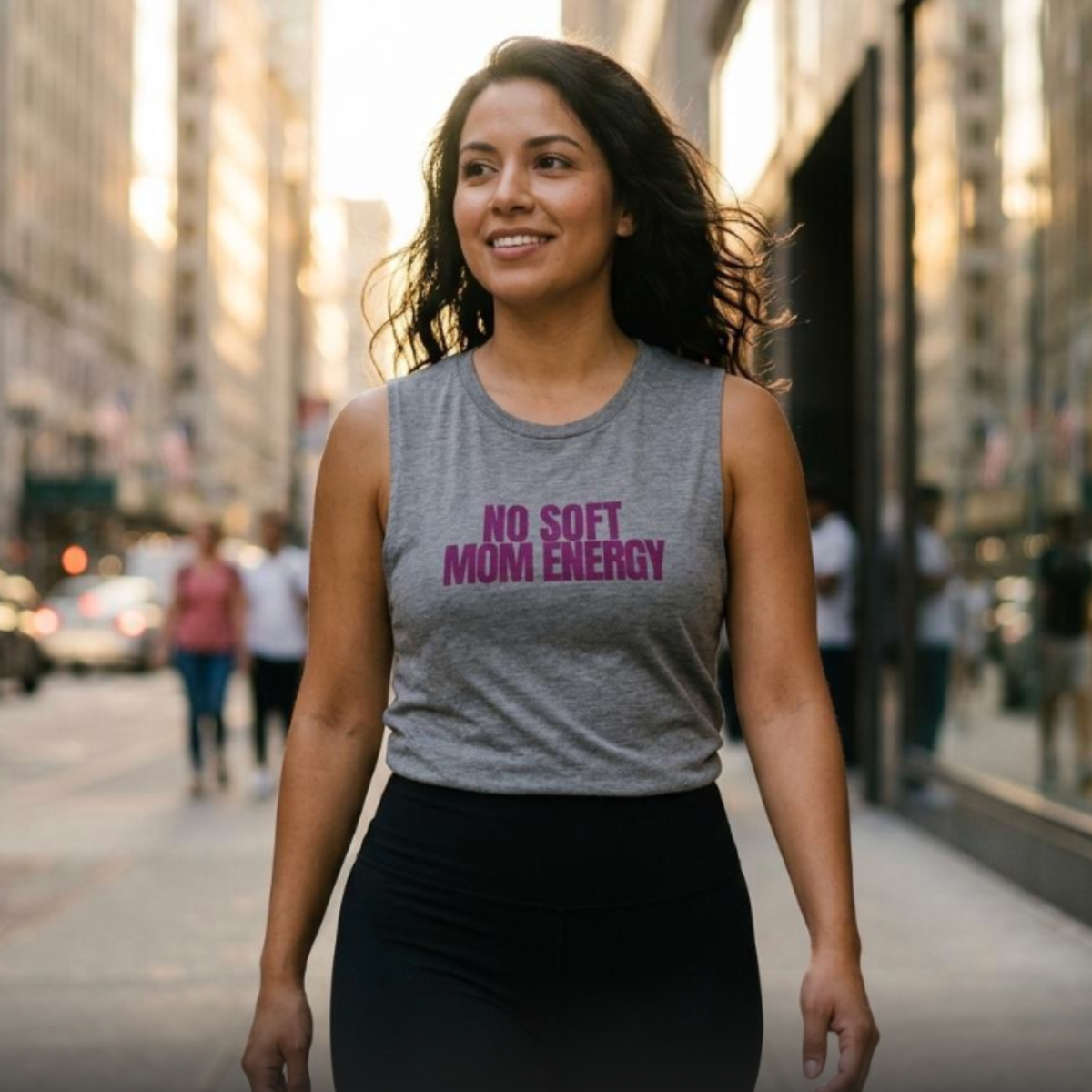 Woman walking outdoors wearing heather gray “No Soft Mom Energy” muscle tank