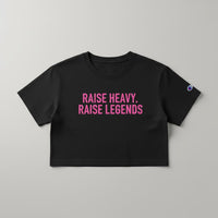 Black women’s cropped Champion tee with pink Raise Heavy Raise Legends graphic flat lay