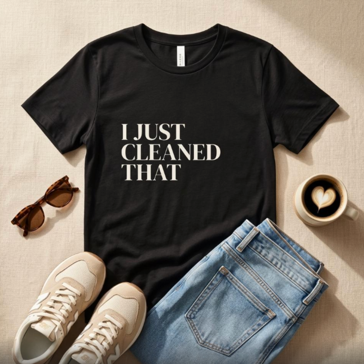 Black “I Just Cleaned That” graphic t-shirt flat lay with jeans and sneakers, casual mom outfit styling