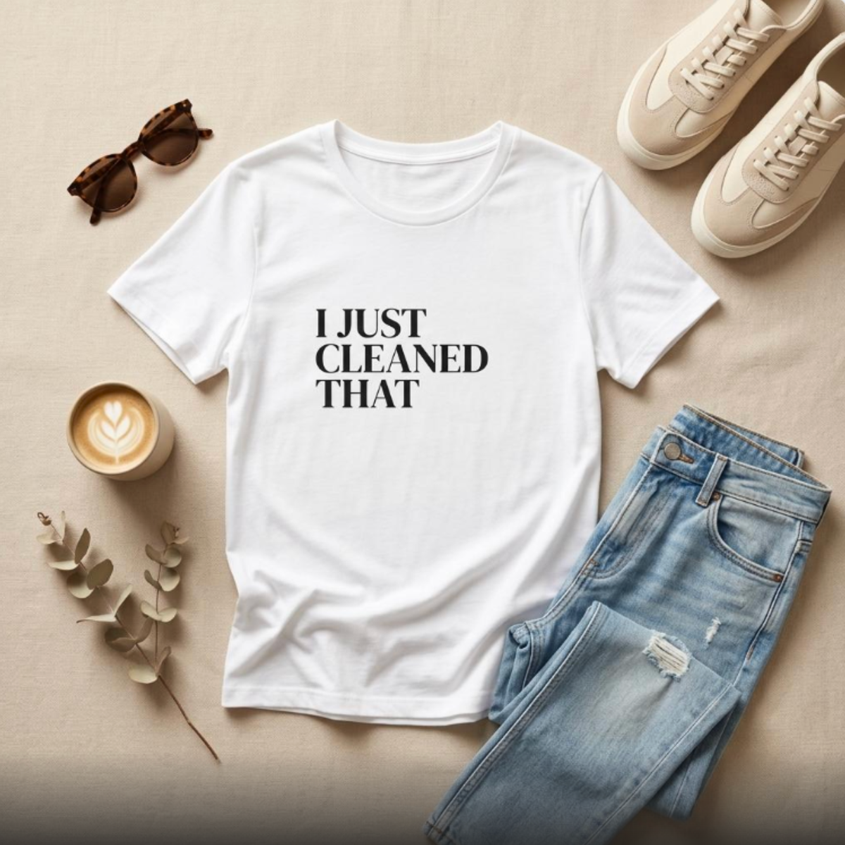 White “I Just Cleaned That” graphic t-shirt flat lay with jeans and accessories, casual mom outfit styling