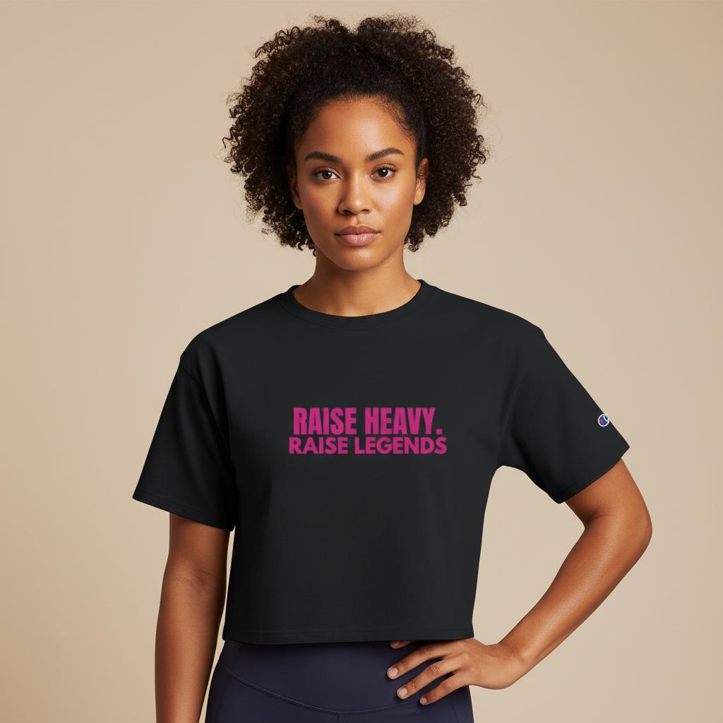 Front view of women’s black cropped Champion tee with pink Raise Heavy Raise Legends design