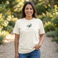 Latina woman wearing Scorpio Mama ivory zodiac mom t-shirt outdoors with greenery background