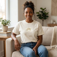 Woman of color wearing Virgo Mama ivory zodiac mom t-shirt seated indoors in neutral living room