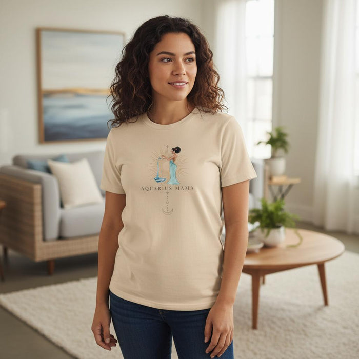 Woman wearing ivory Aquarius Mama zodiac t-shirt in a bright modern living room, watercolor water bearer graphic visible on chest
