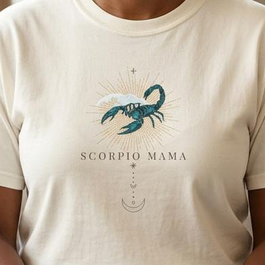 Close-up of Scorpio Mama ivory t-shirt with teal scorpion zodiac graphic on chest