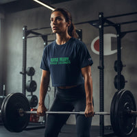 Athletic woman deadlifting in a gym while wearing a navy Raise Heavy Raise Legends cropped workout tee
