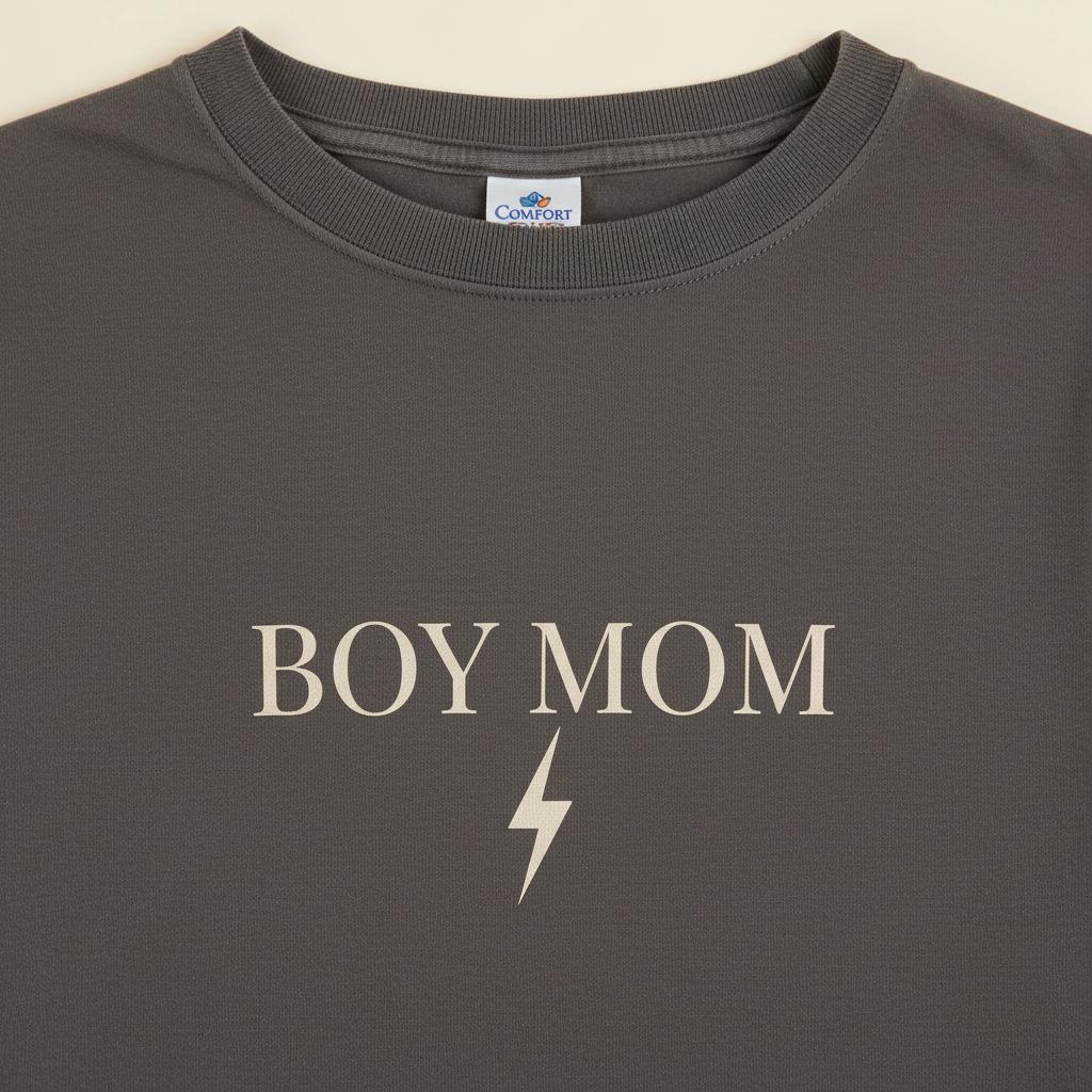 Gray t-shirt with 'BOY MOM' text and lightning bolt on a beige background