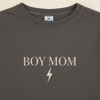 Gray t-shirt with 'BOY MOM' text and lightning bolt on a beige background