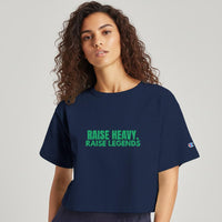 Woman modeling a navy cropped Raise Heavy Raise Legends statement t-shirt in a casual studio setting