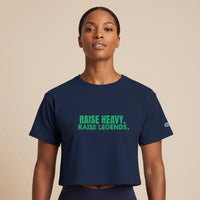 Woman wearing a navy cropped Raise Heavy Raise Legends Champion t-shirt against a neutral studio background